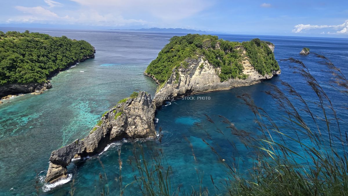 Aerial view of Diamond Beach Bali with turquoise waters, limestone cliffs, and tropical vegetation - stock photo