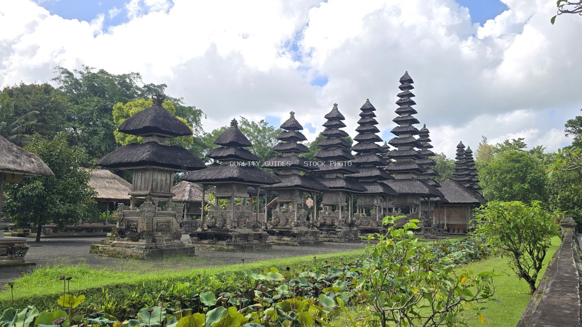 Taman Ayun Temple in Bali with multi-tiered pagoda roofs surrounded by tropical gardens and blue sky - stock photo