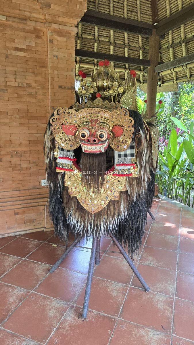 Ornate traditional Balinese Barong mask with gold leaf and black hair in temple pavilion - stock photo