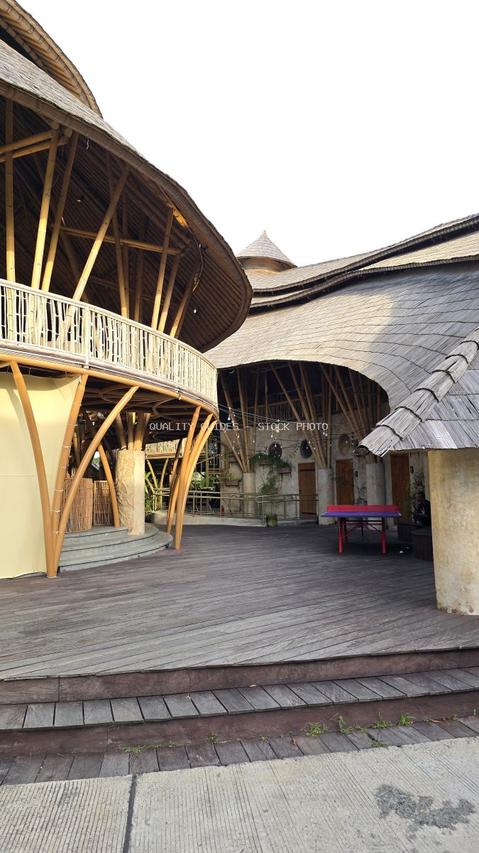 Contemporary Balinese courtyard with curved wooden architecture, white railings, and modern design at Nuanu Creative City - stock photo