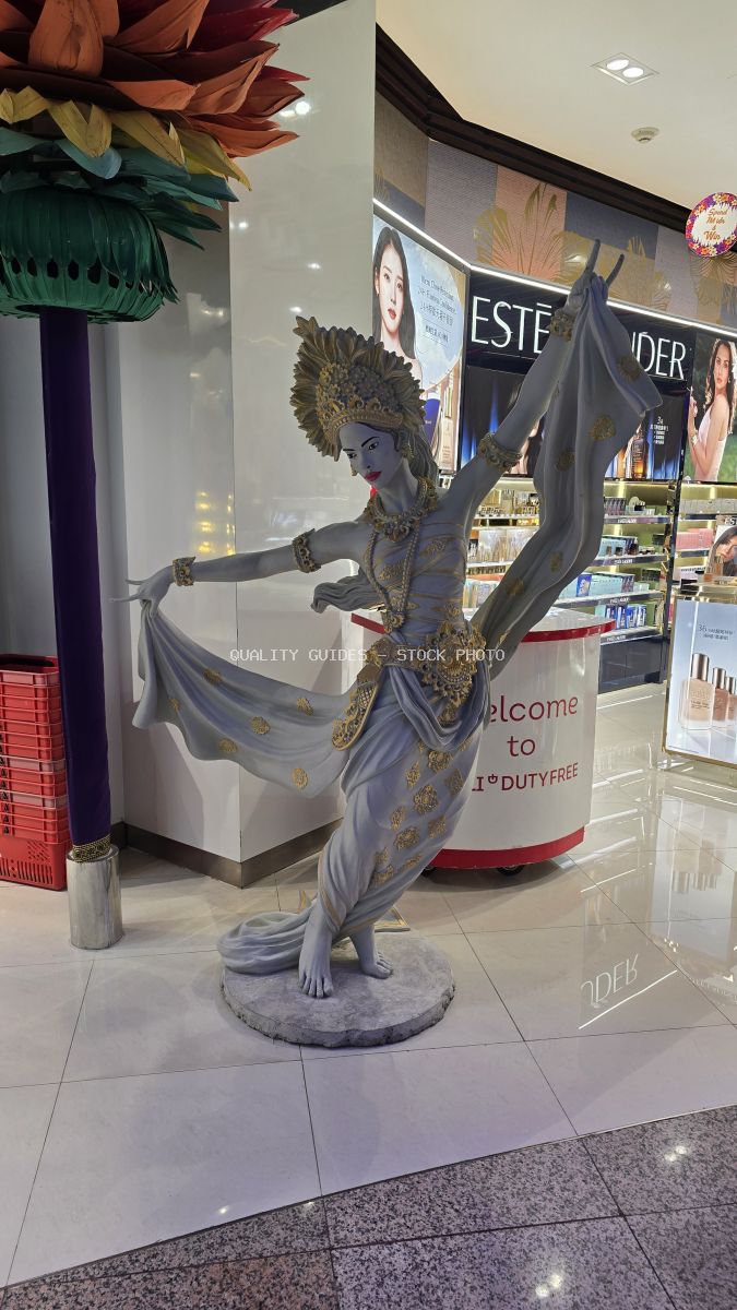 Traditional Balinese dancer statue with gold details in duty-free shop at Bali International Airport - stock photo