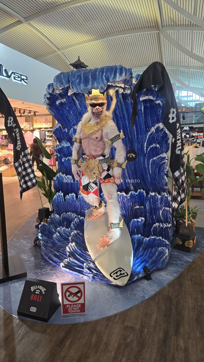 Colorful blue and white surfboard art installation with artistic figure at Bali airport terminal - stock photo