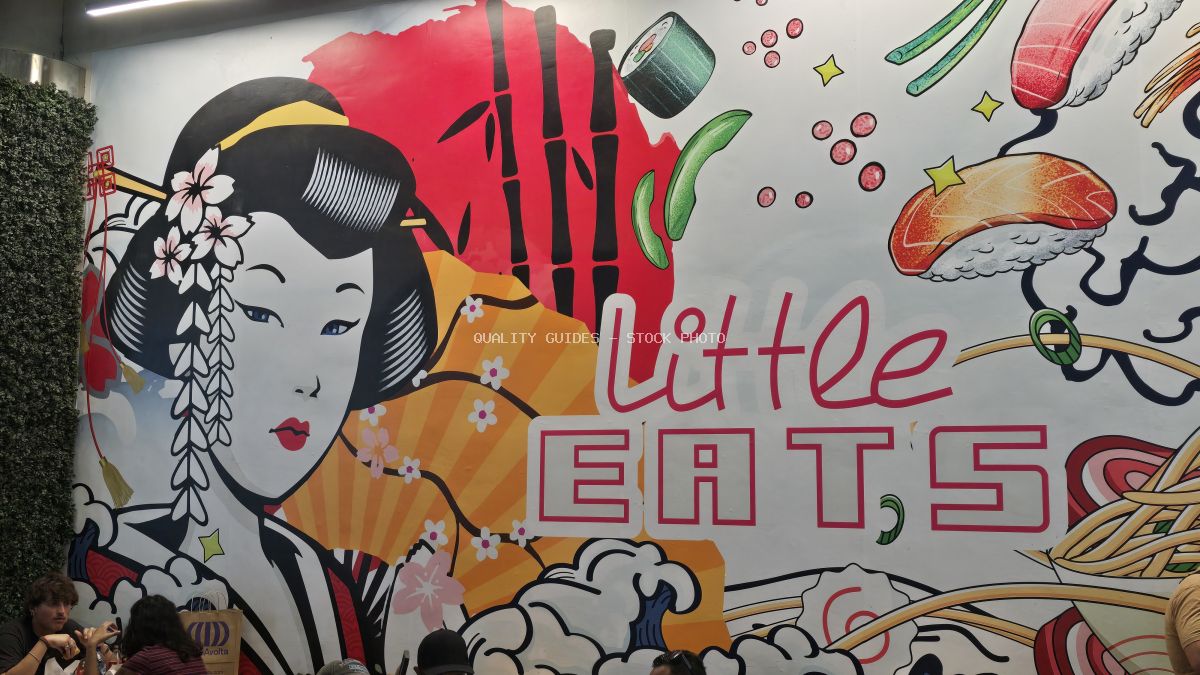 Colorful street art mural featuring Asian woman and food illustrations with "Little EATS" text in Bali - stock photo