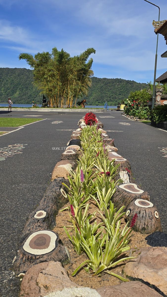 Decorative floral pathway at Ulun Danu Beratan Temple overlooking Lake Beratan and bamboo grove in Bali - stock photo