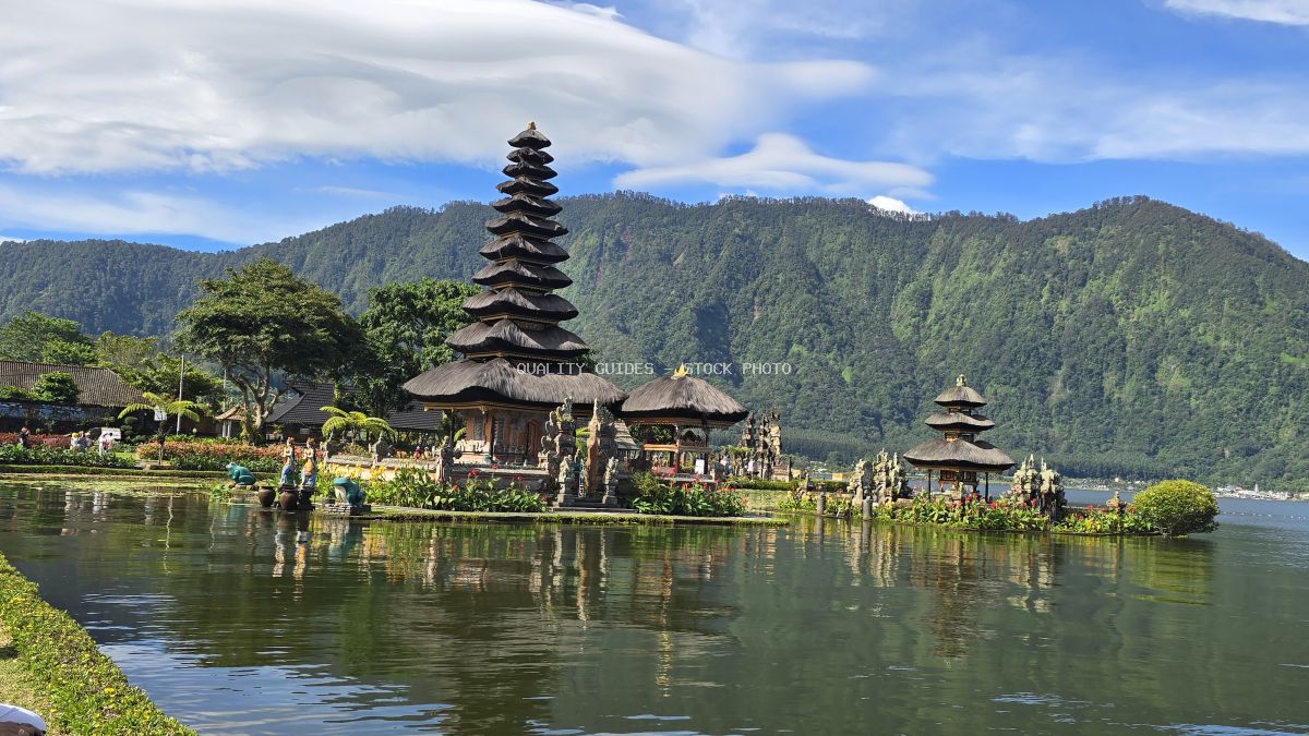 Ulun Danu Beratan Temple reflected in Lake Beratan with tropical mountains in background, Bali Indonesia - stock photo