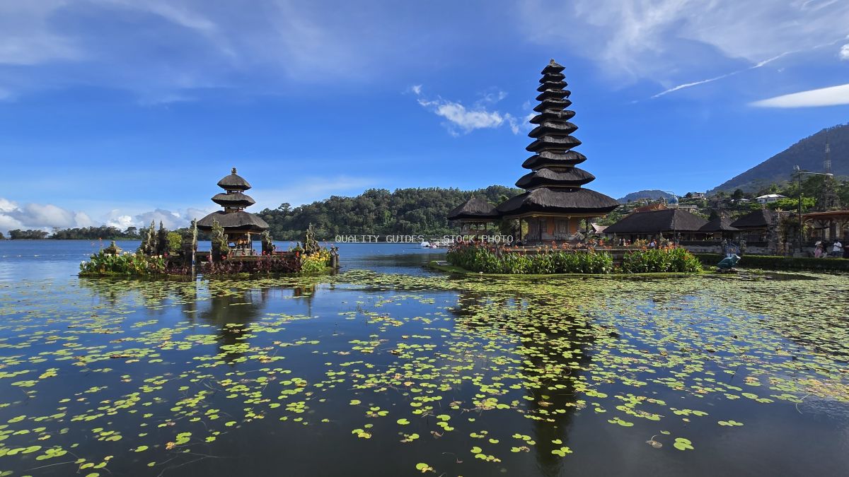 Ulun Danu Beratan Temple in Bali with tiered roofs reflected in lake with water lilies - stock photo