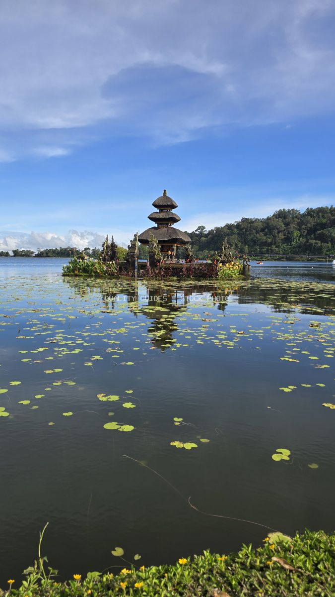 Ulun Danu Beratan Temple on Lake Bratan in Bali with water lilies and tropical forest - stock photo