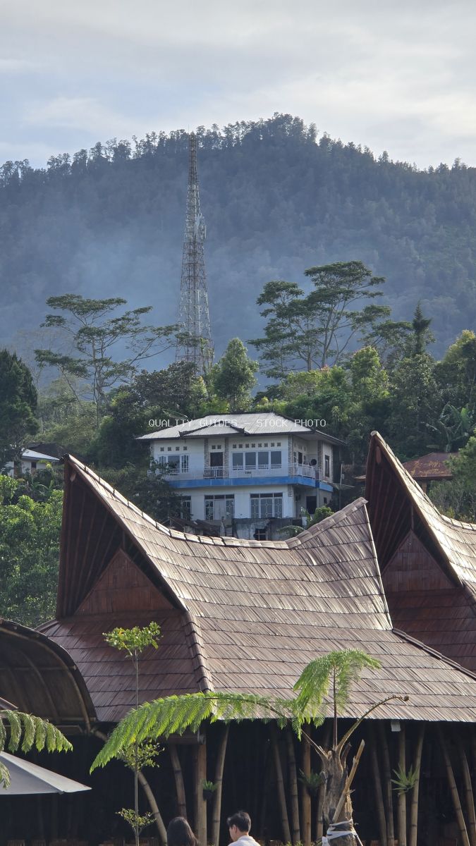 Ulun Danu Beratan Temple with traditional wooden roofs, white building, and misty mountains in Bali - stock photo