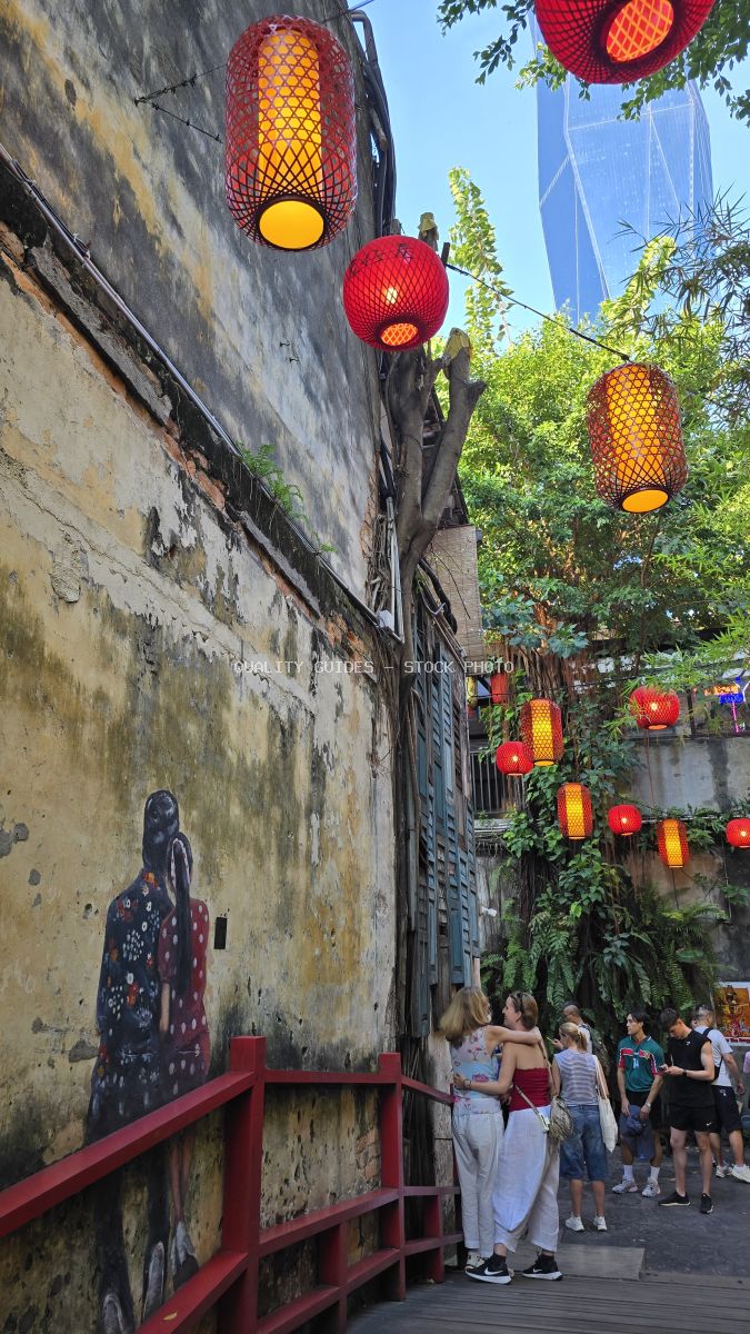 Tourists walking through Kwai Chai Hong heritage alley with red lanterns and street art in Kuala Lumpur - stock photo