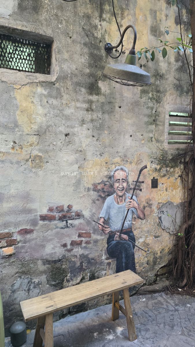 Interactive street art mural of elderly woman on swing with real metal swing installation on weathered wall in Kuala Lumpur - stock photo