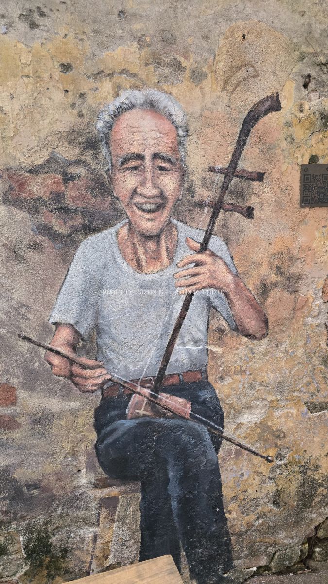 Street art mural of smiling elderly musician with white hair holding violin on weathered wall in Kuala Lumpur - stock photo