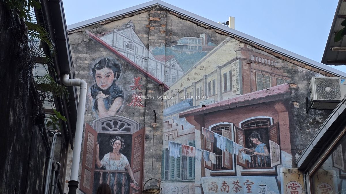 Vintage-style street art mural on heritage building wall in Kwai Chai Hong, Kuala Lumpur, featuring classical Chinese women portraits and traditional shophouse architecture - stock photo
