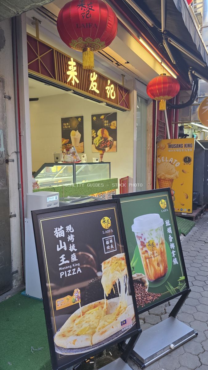 Red lanterns and Chinese signage on an Asian street food shop storefront with menu boards - stock photo