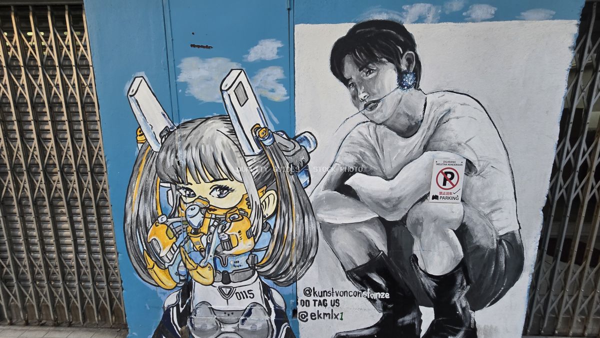 Colorful street art mural with anime character and black and white portrait on blue wall, framed by metal gates - stock photo